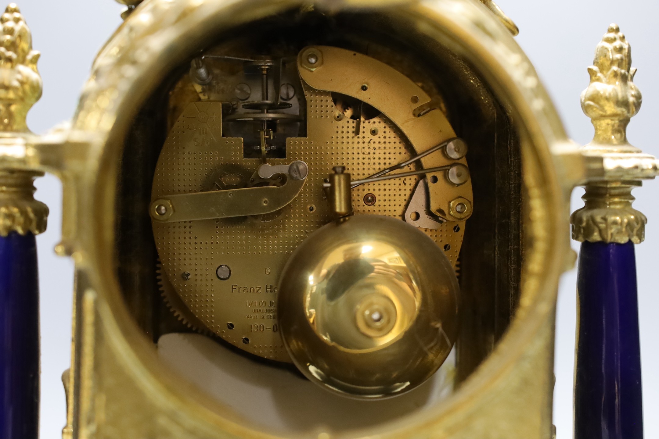 A ornamental gilt French mantel clock with painted porcelain insets - 41.5cm tall